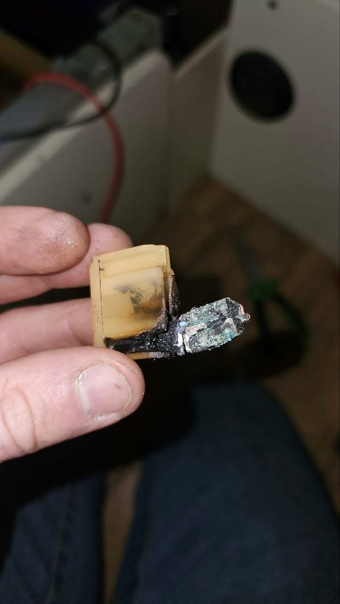 Conector eléctrico quemado retirado de una instalación durante la reparación de una avería
